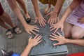 Female hands stacked on a metal plaque with hand imprints. A symbol of teamwork and trust