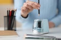 Female hands sticking out pencil in electronic sharpener closeup Royalty Free Stock Photo