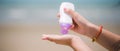 Female hands with sun protection cream at the beach. Skin care concep