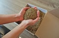 Female hands take grass seeds from a cardboard shipping box. Preparing for sowing a lawn