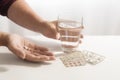 Female hands take pills and a glass of water, blister pack on th Royalty Free Stock Photo