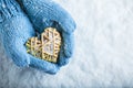 Female hands in teal knitted mittens with a entwined vintage romantic heart on a snow background. Love and St. Valentine concept Royalty Free Stock Photo