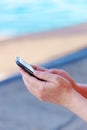 Female hands texting message on mobile phone on seaside Royalty Free Stock Photo