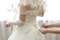 Female hands tightening a corset to the bride