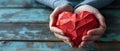 Female Hands Tightly Grip A Red Polygonal Paper Heart Shape