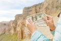 Female hands of a tourist with a fan of dollar bills against the backdrop of the rocks on the journey. The concept of Royalty Free Stock Photo