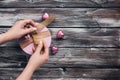 Female hands tying a pink gift box with a gold ribbon on a dark vintage wooden board table. Top view, toned. Festive background Royalty Free Stock Photo