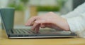 Female hands type on laptop keyboard close up. No face woman sits on sofa freelancing working at home writes post Royalty Free Stock Photo