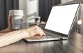 Female hands typing on laptop keyboard and holding takeaway cup. Woman sitting in cafe, using computer mockup in work or Royalty Free Stock Photo