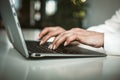 Female hands typing on laptop keyboard in office. Businesswoman working with computer. Close up shot. Tinted image Royalty Free Stock Photo