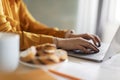 Female Hands Typing On Laptop Keyboard While Sitting At Table In Kitchen Royalty Free Stock Photo