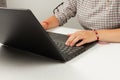 Female hands are typing text on laptop keyboard on white table background Royalty Free Stock Photo