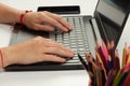 Female hands are typing text on laptop keyboard on white table background Royalty Free Stock Photo