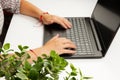 Female hands are typing text on laptop keyboard on white table background Royalty Free Stock Photo