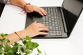 Female hands are typing text on laptop keyboard on white table background Royalty Free Stock Photo