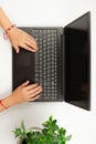 Female hands are typing text on laptop keyboard on white table background Royalty Free Stock Photo