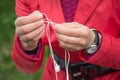 Female hands unravel the white little headphones outdoor