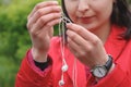 Female hands unravel the white little headphones outdoor