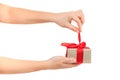 Female hands untie the red ribbon and open the gift. gift your loved one