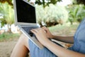 Female hands using laptop with sand in background, black screen. Royalty Free Stock Photo