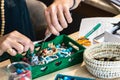 Female hands using pliers to make handmade bijouterie with little balls and stones