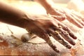 Female hands using a rolling pin to pave a dough over a wooden board dirty with flour Royalty Free Stock Photo