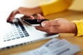 Female hands using smart phone while working on computer. Businesswoman typing text message on her cellphone. Royalty Free Stock Photo