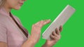 Female hands using tablet on a Green Screen, Chroma Key.