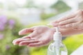 Female hands using wash hand sanitizer gel pump dispenser.