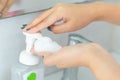 Female hands using wash hand sanitizer gel pump dispenser Royalty Free Stock Photo