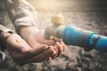 Female hands want to drink some water in faucet on crack ground