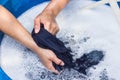 Female hands wash clothing by hand with detergent in basin. selective focus and space for text.