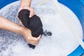 Female hands wash clothing by hand with detergent in basin. selective focus and space for text.