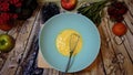 female hands whip eggs in bowl on the kitchen table by the window, top view