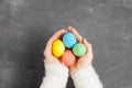 Female hands in a white fluffy sweater hold colorful easter eggs over a chalk board Royalty Free Stock Photo