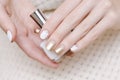 Female hands with white and gold nail design