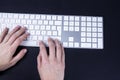 Female hands on the white keyboard on black baground. Typing, writing, freelance and working from home keyboard.