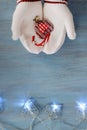 Female Hands In White Knitted Mittens With Entwined Vintage Romantic Red Heart On blue Background