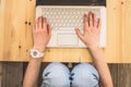 Female hands on white on laptop with black cover on wooden surface top view Royalty Free Stock Photo