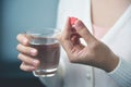 Female hands with white shirt is holding red pill in heart shape Royalty Free Stock Photo