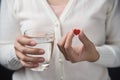 Female hands with white shirt is holding red pill in heart shape Royalty Free Stock Photo