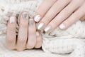Female hands with white and silver nail design