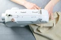 Female hands work on a sewing machine, sewing coffee towel. Close-up Royalty Free Stock Photo