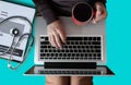 Female hands working on modern laptop. Top view of doctor desk table with stethoscope, coffee, Medical gown and notebook with pen Royalty Free Stock Photo