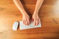 Female hands working with modern white keyboard and mouse on wooden background, top view  - Image Royalty Free Stock Photo