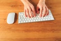 Female hands working with modern white keyboard and mouse on wooden background, top view  - Image Royalty Free Stock Photo
