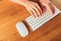 Female hands working with modern white keyboard and mouse on wooden background, top view  - Image Royalty Free Stock Photo