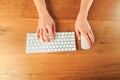 Female hands working with modern white keyboard and mouse on wooden background, top view  - Image Royalty Free Stock Photo