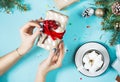 Female hands wrapping christmas gift box above blue table. Top view Royalty Free Stock Photo
