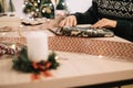 Female hands wrapping Christmas gifts on desk